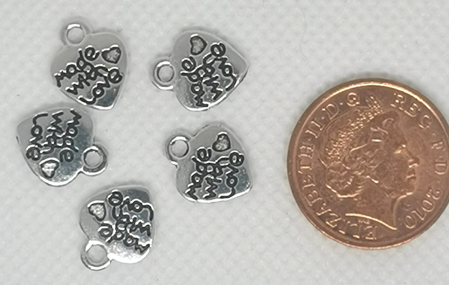 Heart shaped small pendants / tags, antique silver colour, stamped "made with love", approx 10mm wide, 12.2mm high, 1.8mm thick, hole: 2mm