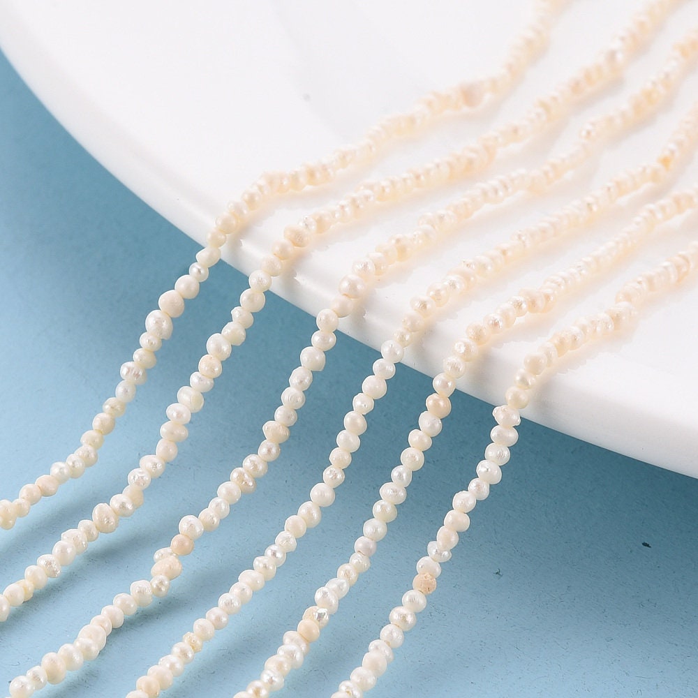 Approx 130 tiny natural cultured freshwater seed pearls, seashell colour, approximately 1.5mm x 1.5mm, drilled, hole approximately 0.5mm