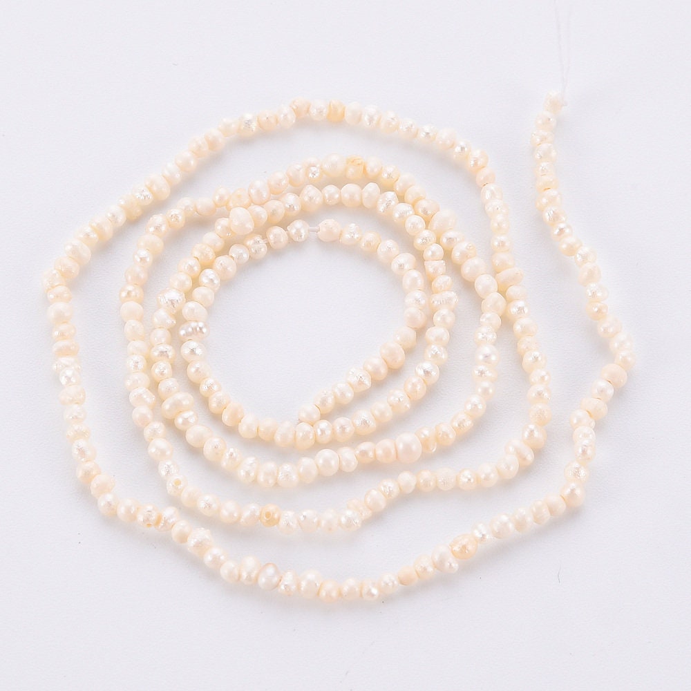 Approx 130 tiny natural cultured freshwater seed pearls, seashell colour, approximately 1.5mm x 1.5mm, drilled, hole approximately 0.5mm