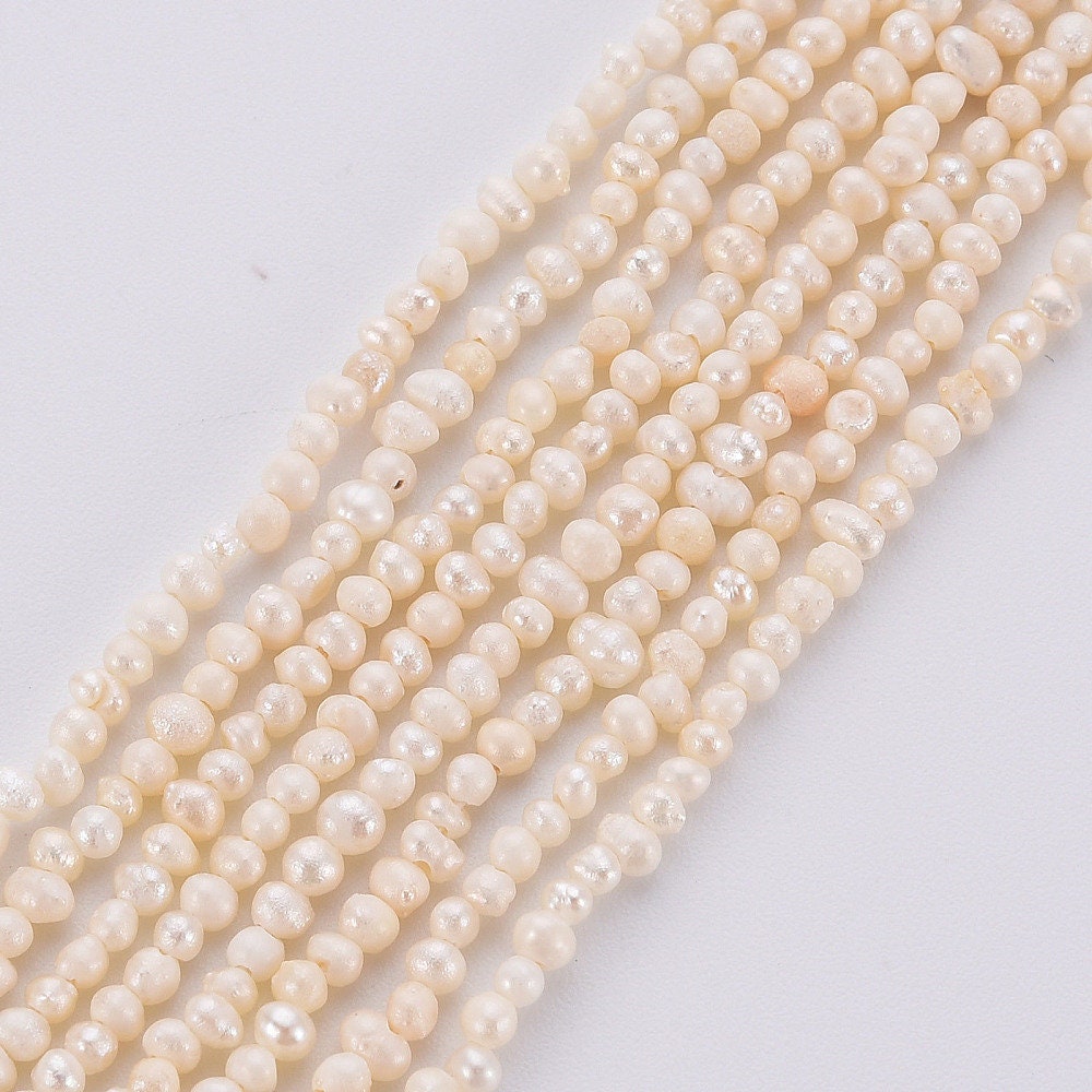 Approx 130 tiny natural cultured freshwater seed pearls, seashell colour, approximately 1.5mm x 1.5mm, drilled, hole approximately 0.5mm