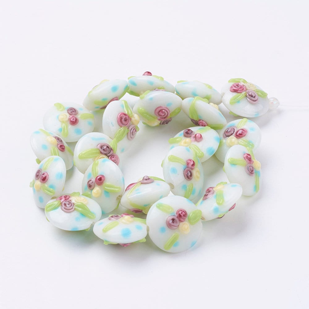 2 x  handmade flat disc lampwork beads, white, raised small roses, blue, green, yellow pattern, approx 18mm x 12 mm, drilled with 2mm hole