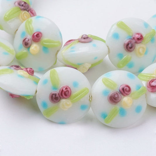2 x  handmade flat disc lampwork beads, white, raised small roses, blue, green, yellow pattern, approx 18mm x 12 mm, drilled with 2mm hole